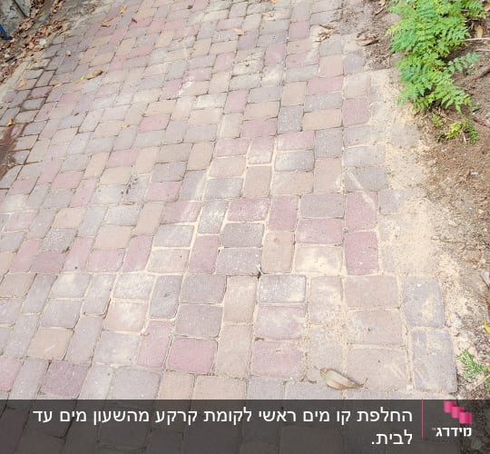 אבנים משתלבות עם צינור שחור לצד שביל